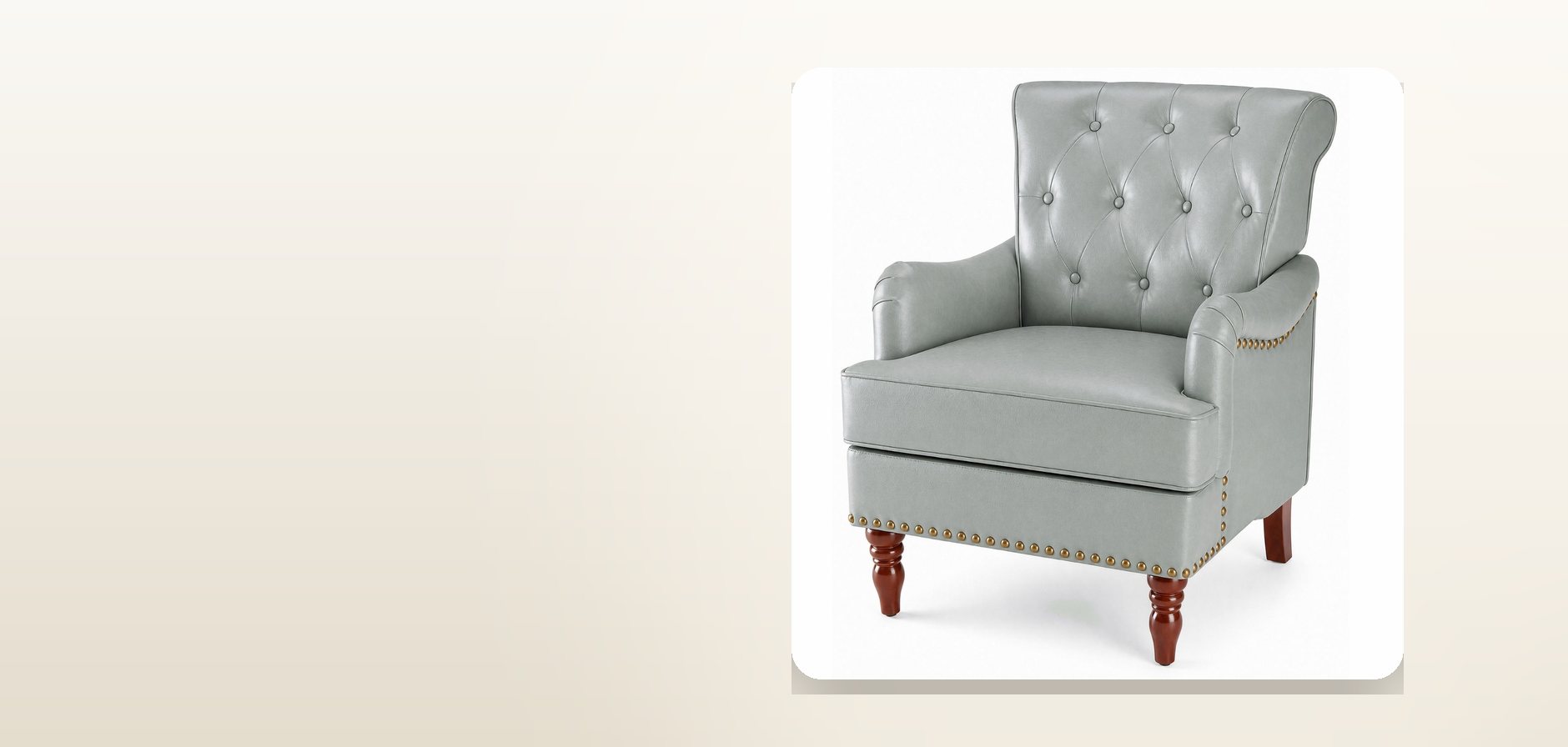 A grey tufted faux-leather armchair with nailhead trim and turned wooden legs, on a pale studio background.